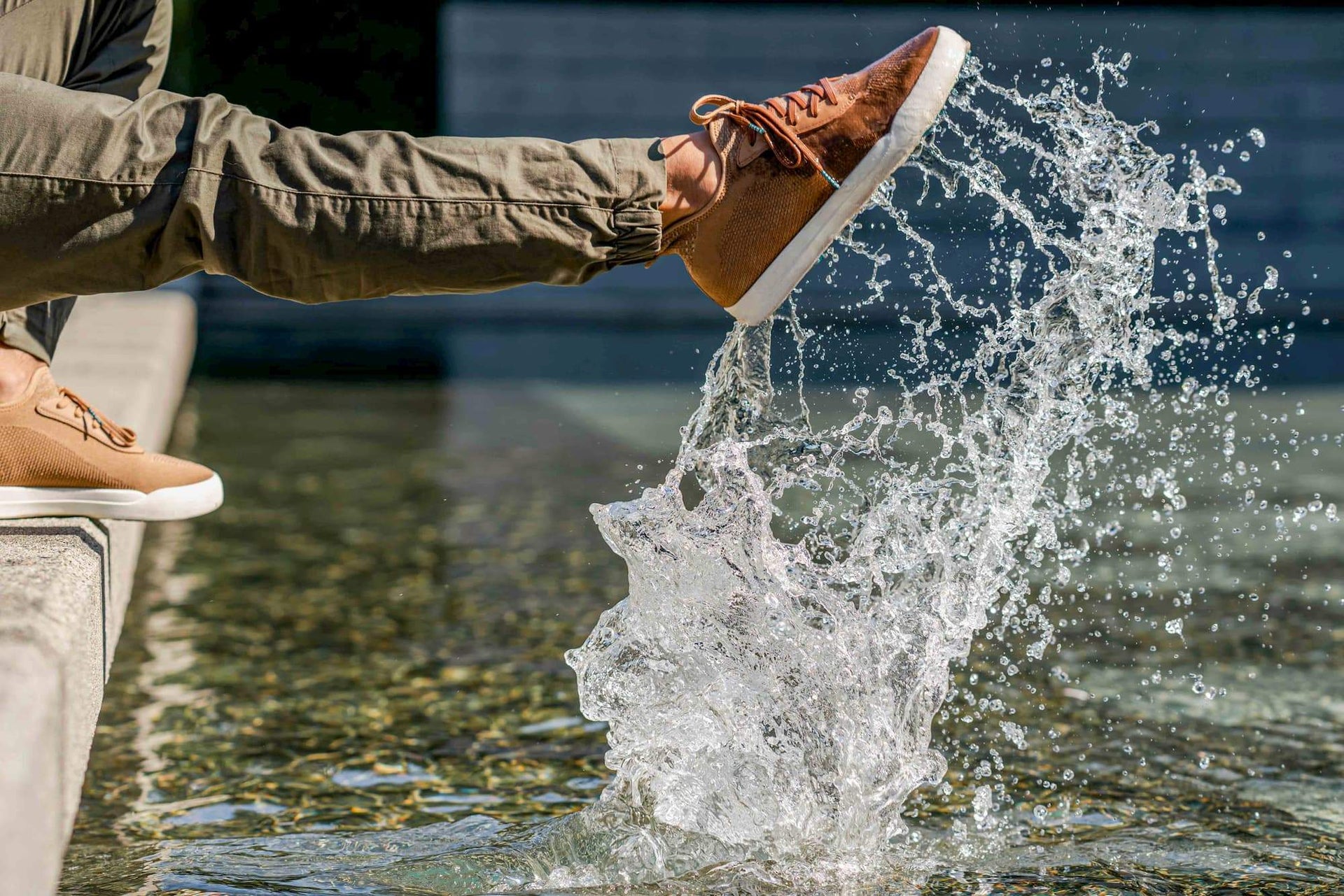 Person splashing their waterproof shoe in the water
