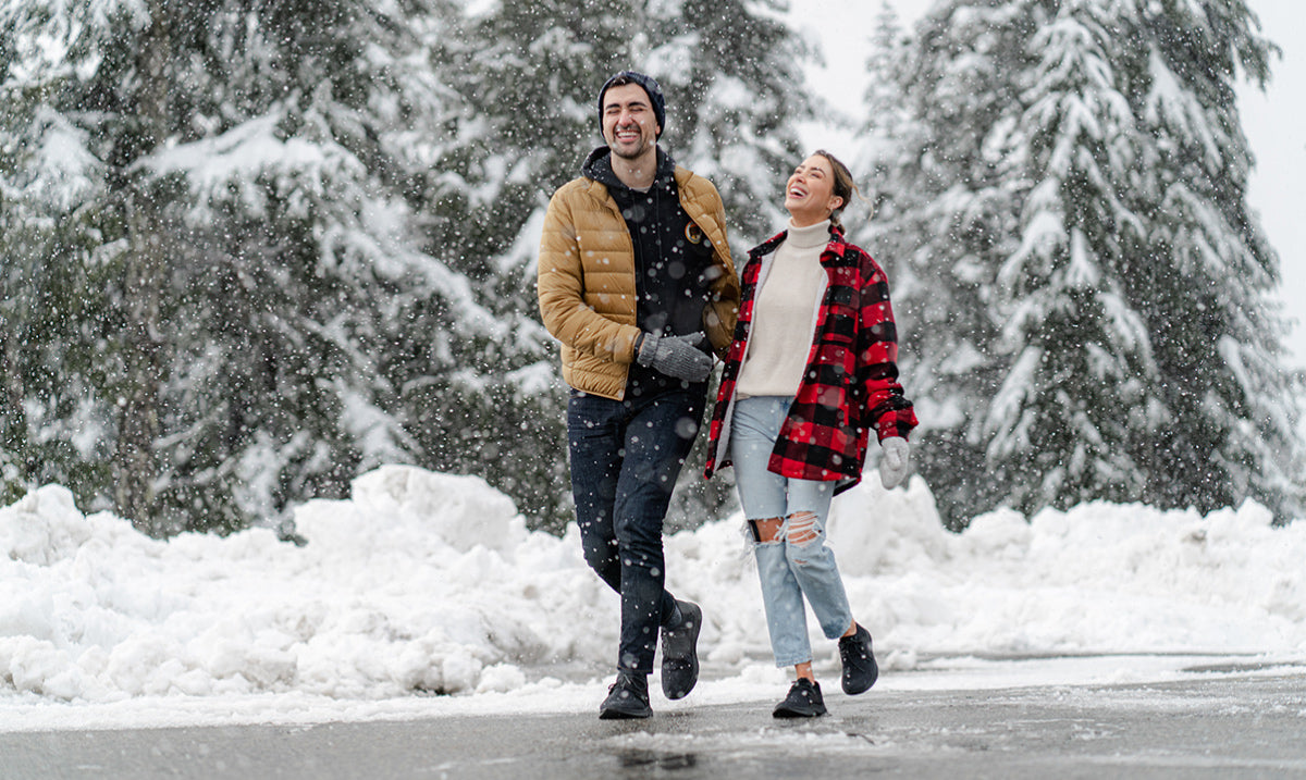 A women and a men wearing Vessi waterproof shoes on a snowy day.