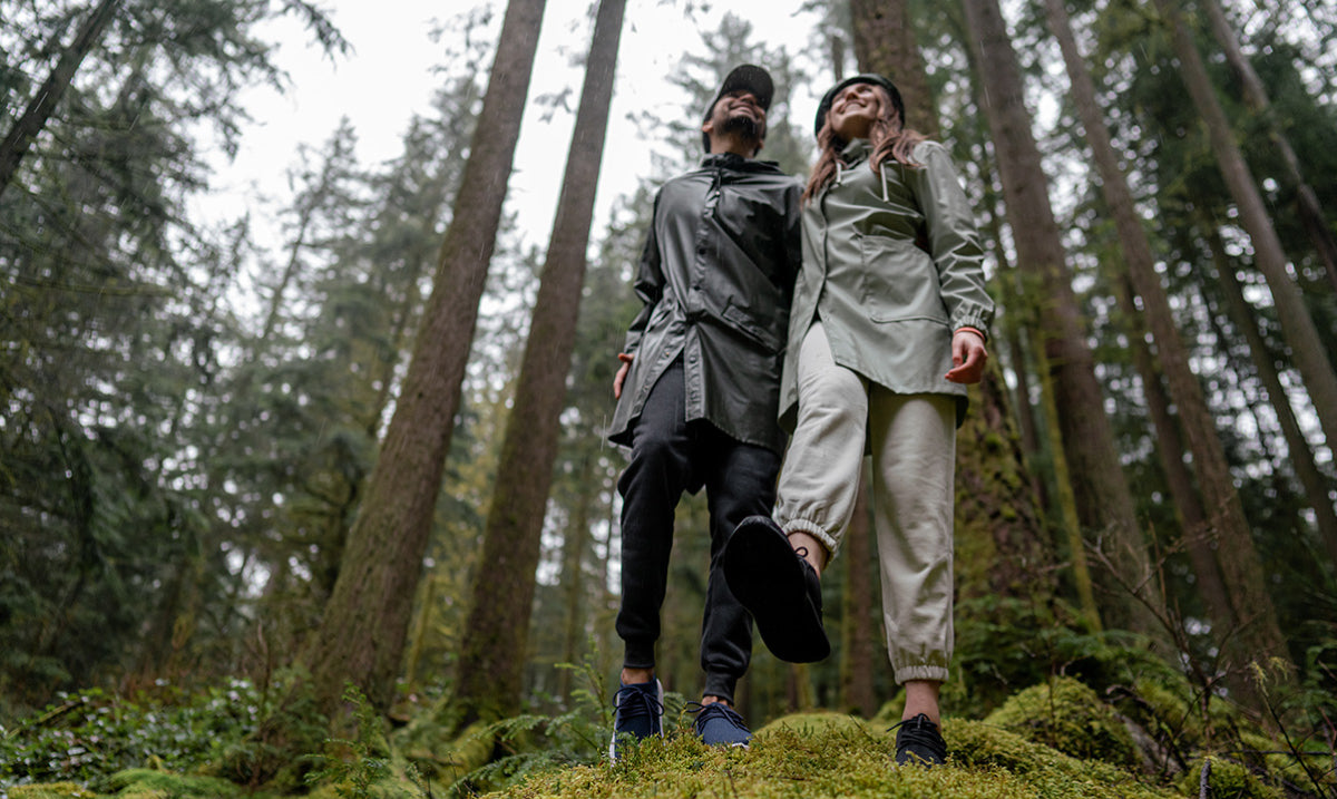 A man and a women hiking on a rainy day wearing rain gear