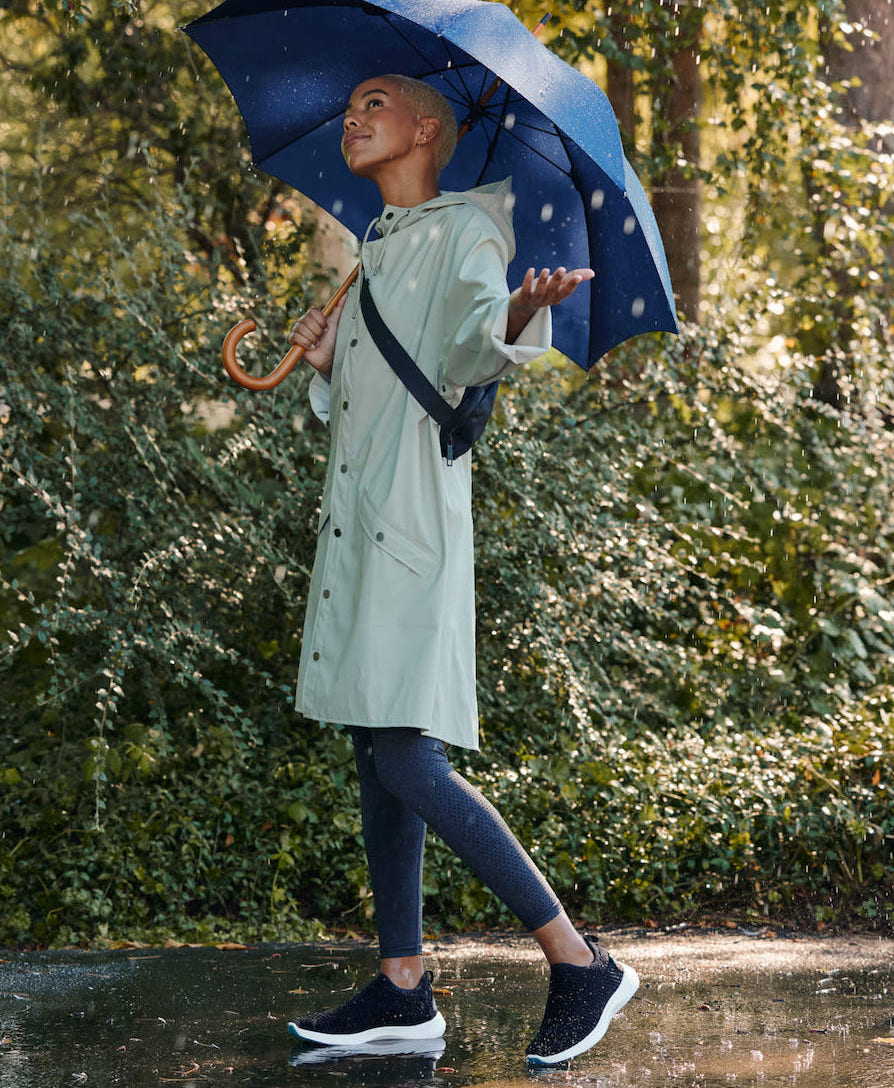 women standing in the rain with an umbrella wearing waterproof sneakers 